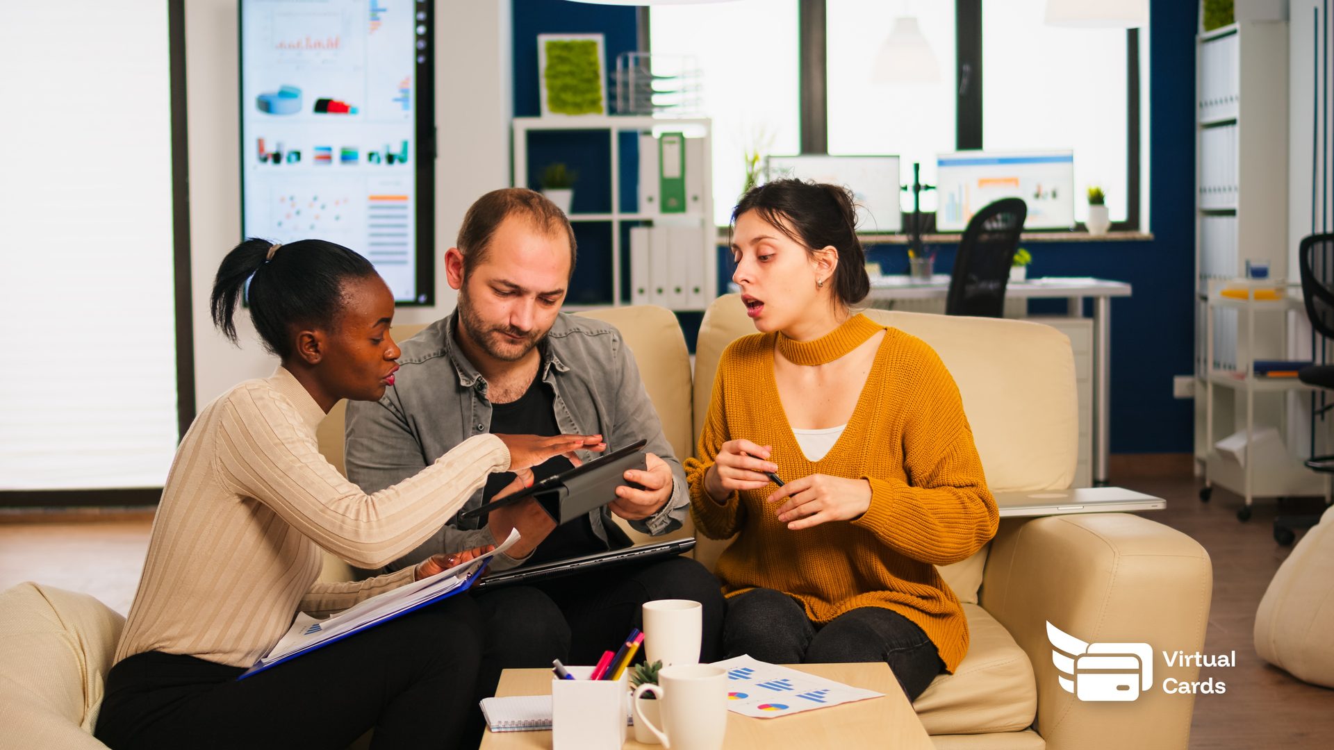 A diverse agency team in a meeting room reviewing client campaign budgets on a laptop, with virtual cards on screen representing each client account.
