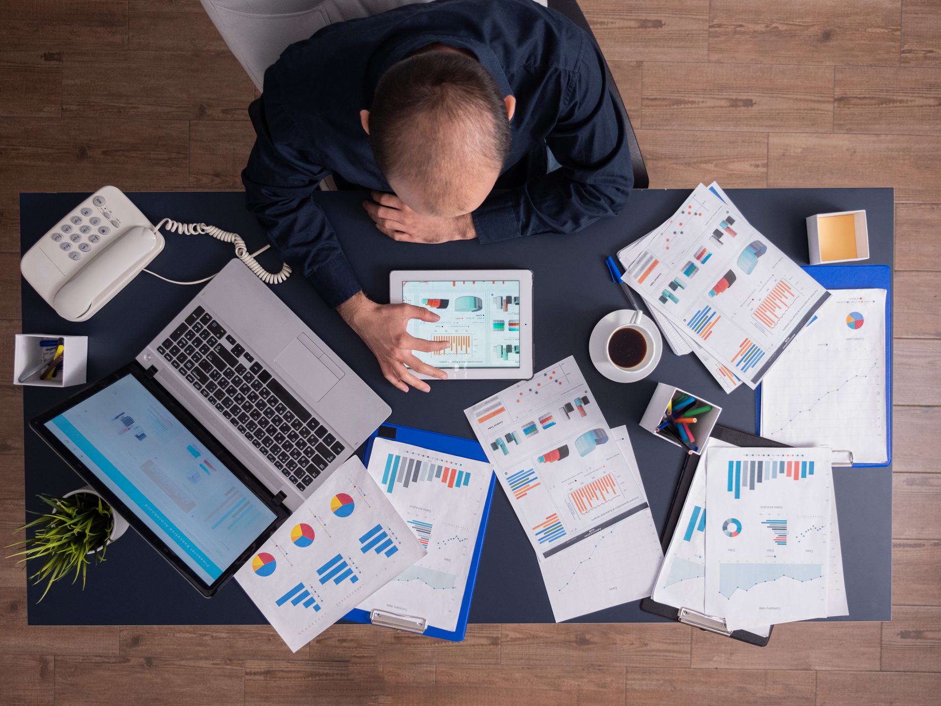 Business analyst reviewing financial reports and charts spread across a desk